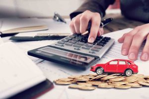 Car with calculator and pen on word tax. Concept of car tax.